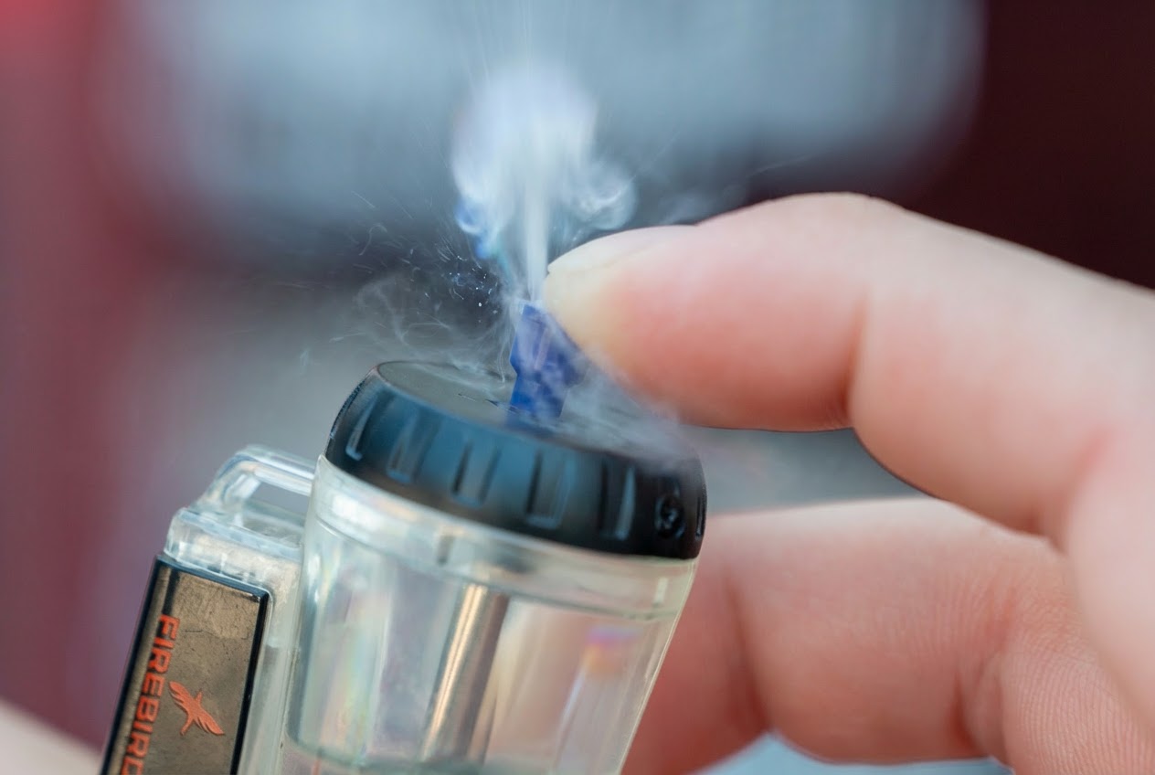 Purging a butane torch cigar lighter by pressing the refill valve to release trapped air and fuel vapor