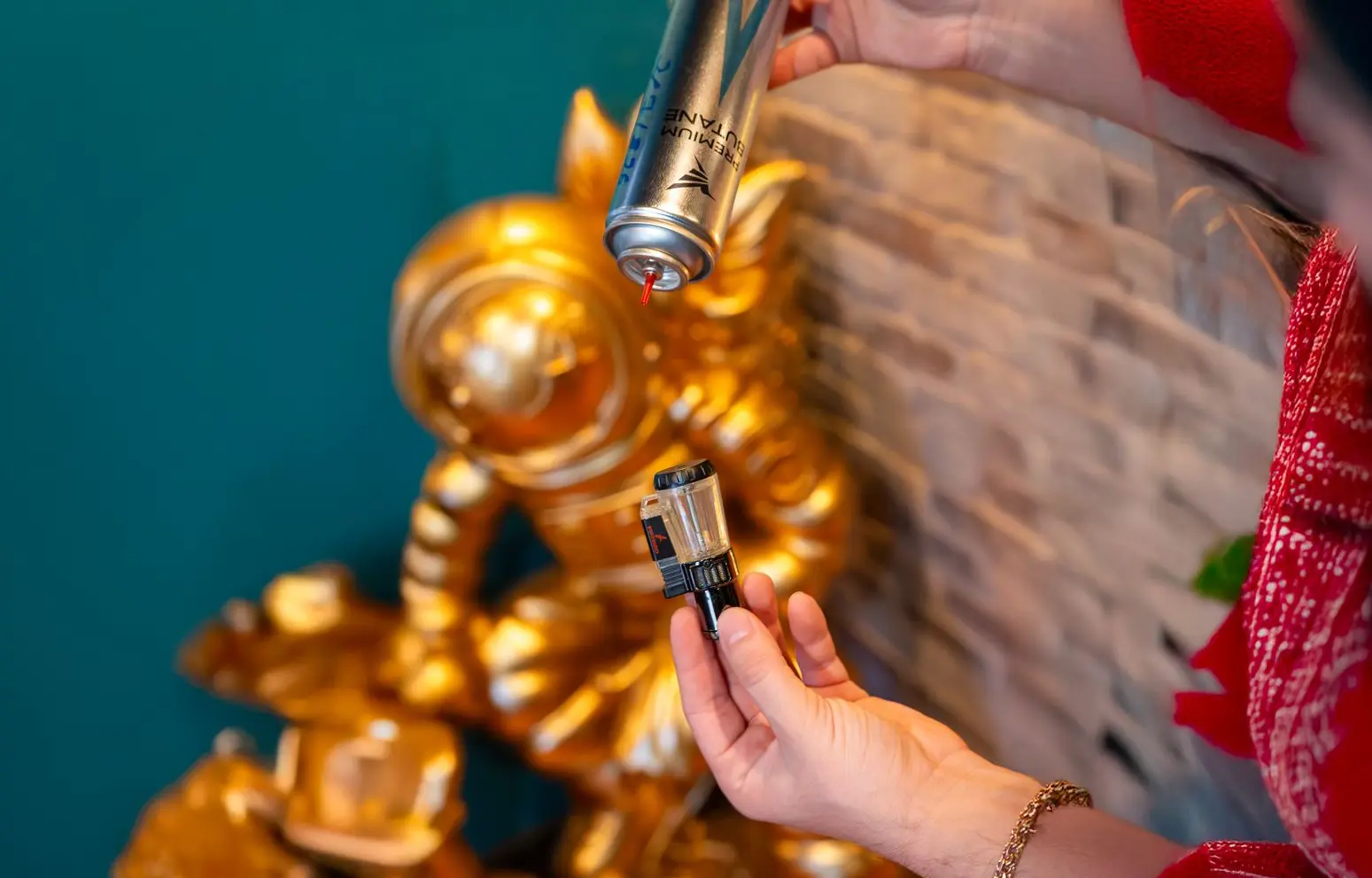 Hold the lighter and butane can upside down and align the nozzle with the refill valve before pressing